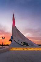 UZBEKISTAN, TASHKENT - SEPTEMBER 15, 2023 Monument of Independence in the form of a stele with a Humo bird on a twilight with dramatic cliods in the New Uzbekistan park. photo