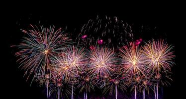 Colorful celebration fireworks isolated on a black sky background. photo