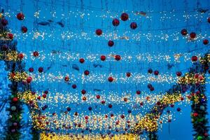 New Year or Christmas festive balls and garlands hanging in rows against the night sky. photo