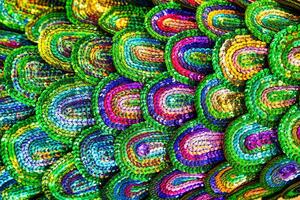 Beautiful multi-colored sequins shimmering in the light in the form of a peacock tail. Abstract background. photo