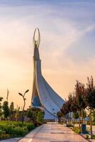 uzbekistán, Tashkent - septiembre 15, 2023 Monumento de independencia en el formar de un estela con un humo pájaro en un crepúsculo con dramático clidos en el nuevo Uzbekistán parque. foto