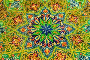 Colorful vintage oriental ornament painted on the tabletop. Abstract background. photo