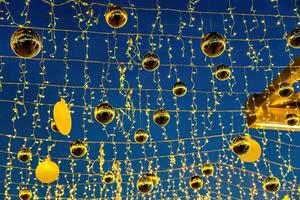 New Year or Christmas festive golden balls hanging in rows against the night sky. photo