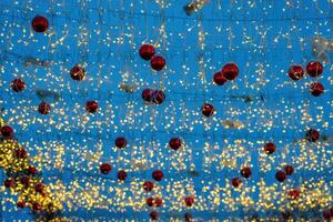 New Year or Christmas festive balls and garlands hanging in rows against the night sky. photo