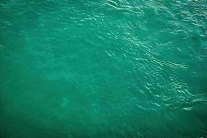 The texture of the waves of turquoise color of fast-flowing water in the river. photo