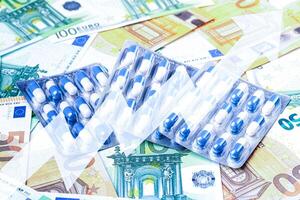 Plate with pills on the background of euro bills. photo
