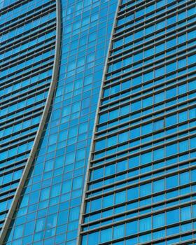 Fragment of a modern office building. Abstract geometric background. Part of a skyscraper with glass windows. photo