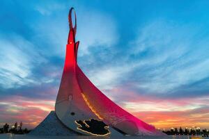 UZBEKISTAN, TASHKENT - SEPTEMBER 15, 2023 Monument of Independence in the form of a stele with a Humo bird on a twilight with dramatic cliods in the New Uzbekistan park. photo