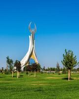 UZBEKISTAN, TASHKENT - SEPTEMBER 15, 2023 Monument of Independence in the form of a stele with a Humo bird on a daytime in the New Uzbekistan park in summer. photo