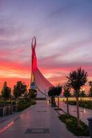 UZBEKISTAN, TASHKENT - SEPTEMBER 15, 2023 Monument of Independence in the form of a stele with a Humo bird on a twilight with dramatic cliods in the New Uzbekistan park. photo