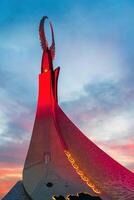 uzbekistán, Tashkent - septiembre 15, 2023 Monumento de independencia en el formar de un estela con un humo pájaro en un crepúsculo con dramático clidos en el nuevo Uzbekistán parque. foto
