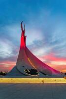 UZBEKISTAN, TASHKENT - SEPTEMBER 15, 2023 Monument of Independence in the form of a stele with a Humo bird on a twilight with dramatic cliods in the New Uzbekistan park. photo