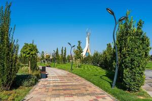 UZBEKISTAN, TASHKENT - SEPTEMBER 15, 2023 Monument of Independence in the form of a stele with a Humo bird on a daytime in the New Uzbekistan park in summer. photo
