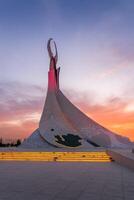 UZBEKISTAN, TASHKENT - SEPTEMBER 15, 2023 Monument of Independence in the form of a stele with a Humo bird on a twilight with dramatic cliods in the New Uzbekistan park. photo