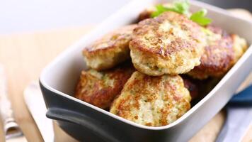 fried meat cutlets in a ceramic form on a wooden table video