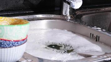 fechar acima do mão fazendo prato lavando dentro a moderno cozinha afundar. Alto qualidade 4k cenas video
