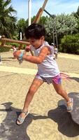 patio de recreo para niños en un parque, ocupado con emocionado y alegre niños teniendo divertido y jugando en tiovivo, deslizar, teatro y columpio y corriendo alrededor. video