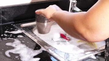 dichtbij omhoog van hand- aan het doen schotel het wassen in de modern keuken wasbak. hoog kwaliteit 4k beeldmateriaal video