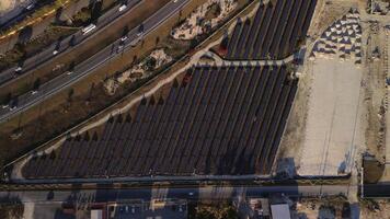 Top view of a new solar farm and highway. Rows of modern photovoltaic solar panels. Renewable ecological source of energy from the sun. Aerial view. Sunset. video