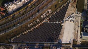 oben Aussicht von ein Neu Solar- Bauernhof und Autobahn. Reihen von modern Photovoltaik Solar- Tafeln. verlängerbar ökologisch Quelle von Energie von das Sonne. Antenne Sicht. Sonnenuntergang. video