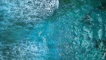 Top down aerial view captures dramatic texture and power of large, dark ocean waves with white foam during stormy day in Caribbean Sea. Drone films breaking surf and foam as big swell hits waters video