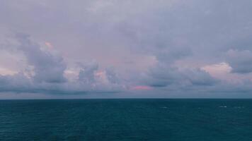 antenn se galet skön oceanisk solnedgång landskap med mjukt rosa moln och turkos vatten video