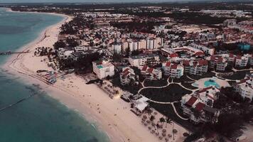 uma crepúsculo voar acima uma renomado costeiro turista cidade, Onde a de praia encontra a Horizonte incandescente com deslumbrante luzes, formando uma hipnotizante visão. isto é punta cana dentro a dominicano república video