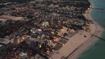 Stunning drone footage reveals coastal city at dusk breathtaking aerial view. Sparkling city lights below create mesmerizing scene in this tourist destination located in Punta Cana, Dominican Republic video