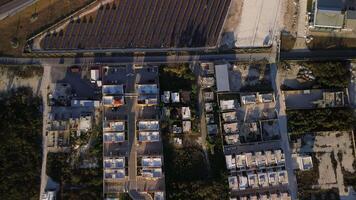 topo Visão do uma Novo solar Fazenda e autoestrada. linhas do moderno fotovoltaico solar painéis. renovável ecológico fonte do energia a partir de a Sol. aéreo visualizar. pôr do sol. video