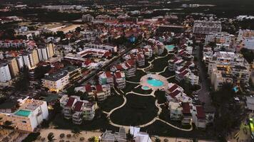 ein Antenne Aussicht von ein Beliebt Küsten Tourist Stadt beim Dämmerung, mit ein luxuriös Hotel mit beleuchtet Schwimmbad. Stadt Beleuchtung unten funkeln, Erstellen ein faszinierend Sicht. diese punta Kana, dominikanisch Republik video