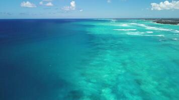 fascinant turquoise des eaux de Caraïbes mer éclat en dessous de radiant soleil, orné avec duveteux des nuages et bordé par tropical littoral de punta Cana, dominicain république. abstrait toile de fond video