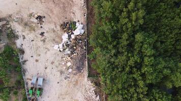 aereo Visualizza di ambientale crisi nel il giungla - mostrando spazzatura scarico, inquinamento, abbandonato macchinari, e ecologico danno. fuco telecamera discende mentre cattura il scena a partire dal sopra. video