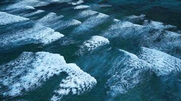 intenso oscuro olas con espumoso blanco crestas. aéreo imágenes de Tormentoso caribe mar mareas en el dominicano república, demostración rotura navegar y mar corales en el barrera arrecife video