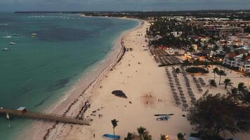 flyg över de strand av en populär turist kust stad på skymning. de stad Nedan pärlar med lampor, skapande en hisnande skådespel. punta kana, Dominikanska republik video