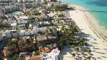 Aerial view voyage over Punta Cana resort area, encompassing Los Corales and El Dorado. Scenery highlights condominiums nestled amid stunning sunset backdrop in Dominican Republic, forward flight video