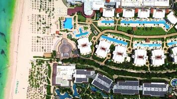 An aerial perspective of a tropical resort in Punta Cana, Dominican Republic, highlighting the pool area, perfect for family fun during vacations. This resort offers all-inclusive travel amenities video