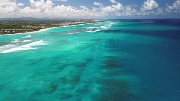 sauvagement magnifique turquoise l'eau de le Caraïbes mer sur une brillant ensoleillé jour, des nuages et le littoral de une tropical île video