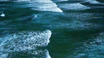 aéreo ver de maravilloso textura y poder de oscuro Oceano olas con blanco espuma video