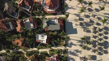 Aerial view captures scenic beauty of tropical tourist destination during sunset, showcasing luxurious condominiums surrounded by palm trees in charming locale. Los Corales, Punta Cana, Dominican video