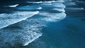 aéreo ver de maravilloso textura y poder de oscuro Oceano olas con blanco espuma video