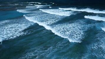 aéreo ver de maravilloso textura y poder de oscuro Oceano olas con blanco espuma video