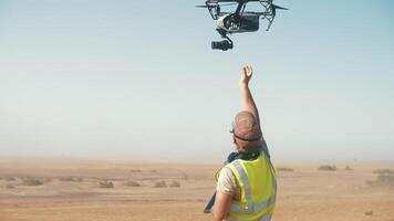 a man catches a drone with a camera in the air on the set of a movie. drone with a camera. filming in the desert. Movie production video