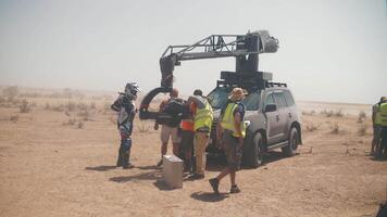 Film Besatzung im das Wüste. Lastwagen eilen entlang das Steppe Straße. Film Produktion video