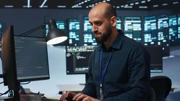 Hardworking engineer feeling happy and celebrating after being able to repair damages in data center facility. Cheerful man pleased after using PC to fix server cabinets errors video