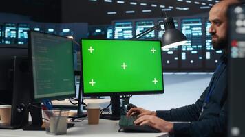 het werknemer programmering Aan groen scherm pc in gegevens centrum behuizing supercomputers opslaan gegevenssets. beheerder schrijven code Aan mockup computer toezicht houden op naar herstellen gegevens centrum rekken video