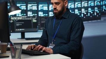 Computer scientist overseeing server hub, typing code on PC, troubleshooting rigs. Software professional doing maintenance on supercomputers, networking systems and storage arrays video