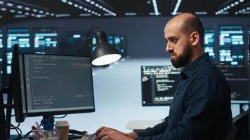 IT engineer overseeing server room, running code on computer, troubleshooting servers. Programmer at work upgrading hardware clusters, networking systems and storage arrays video