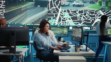 Employee navigating on satellite radar and map to search for routes, helping courier to avoid traffic and successfully deliver orders. Operator in monitoring room using gps coordinates. Camera B. video