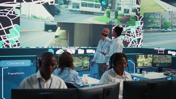 Diverse employees at call center transmitting gps coordinates of routes without traffic to help with express order delivery. Operators following surveillance footage on radar system and map. Camera B. video