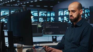 System administrator working in computer network security data center, ensuring optimal performance. Worker monitoring energy consumption across operational server racks components video